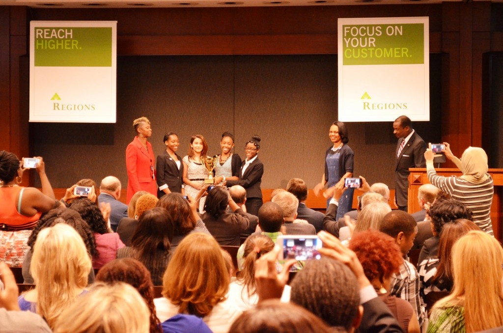 Former U.S. Secretary of State Condoleezza Rice and Leroy Abrahams, right, Regions Bank president for north central Alabama, congratulate the Huffman Middle School students behind Ospedale di Famiglia, the winning business pitched during a “Shark Tank”-style competition. (Michael Tomberlin/Alabama NewsCenter)