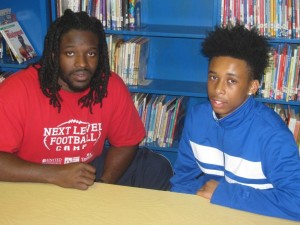 Jeremy Towns sits with Calvin Haggins, 13, in the Putnam Middle School library. Towns serves as a mentor to Haggins, who said he has benefited from the former NFL player’s calming counsel. (Nathan Turner Jr./Alabama NewsCenter)