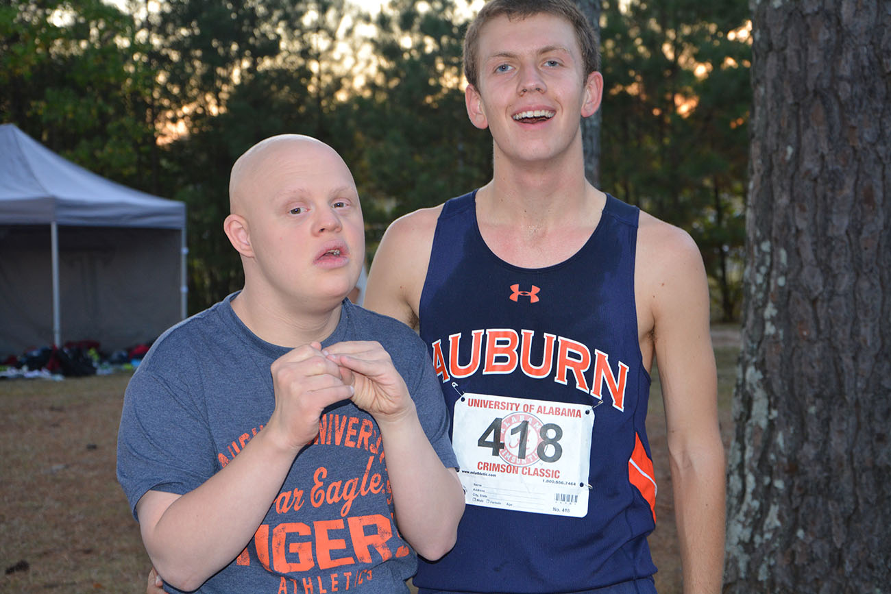 Allen Tucker, left, poses with his brother Alex, a member of Auburn’s track team, at a recent meet. As a child, Allen was treated for leukemia with drugs Southern Research helped develop.
